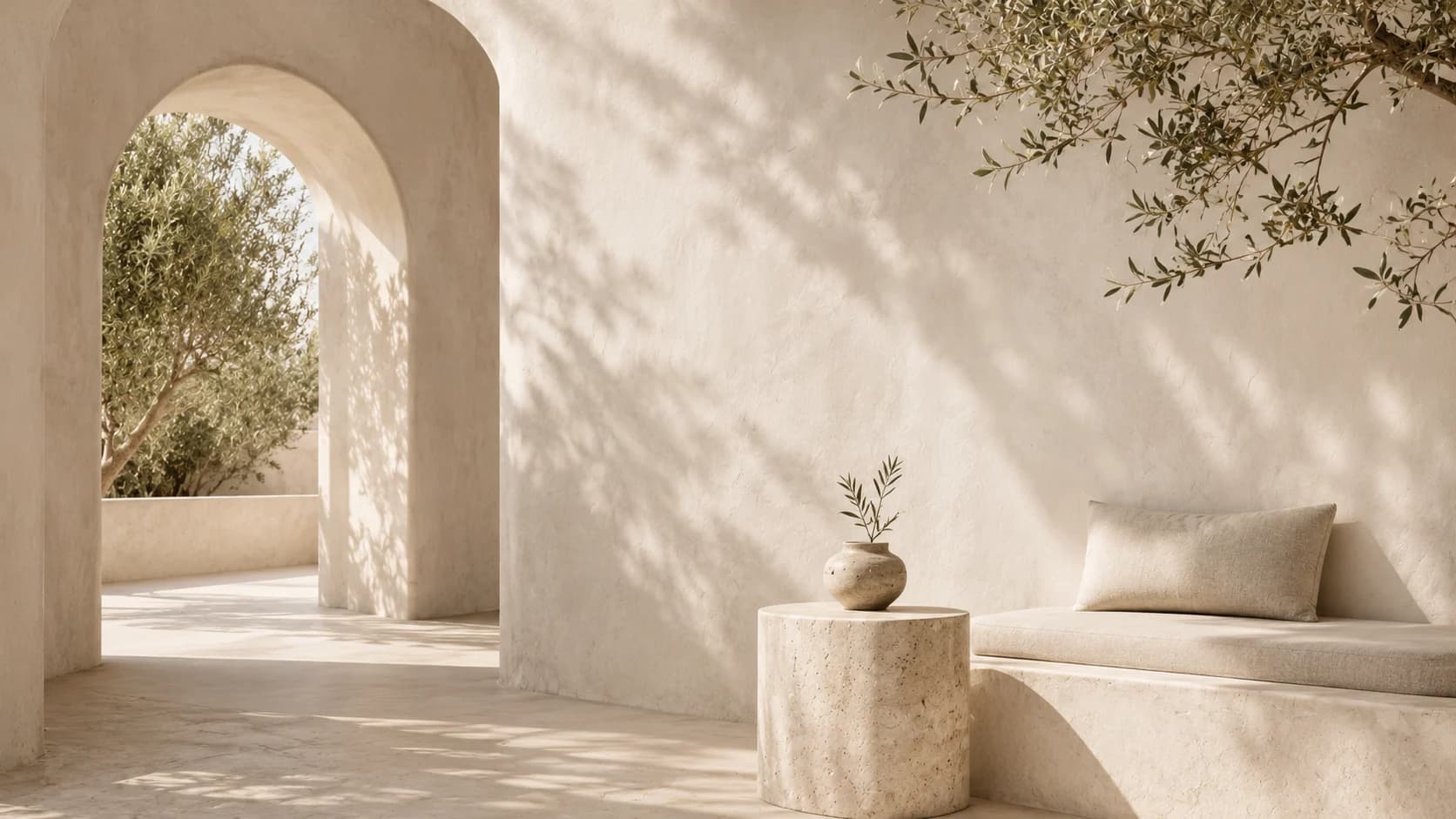 Ein mediterraner Patio mit Bögen, warmem Stein, weichen Sitzplätzen und Küstenlicht.